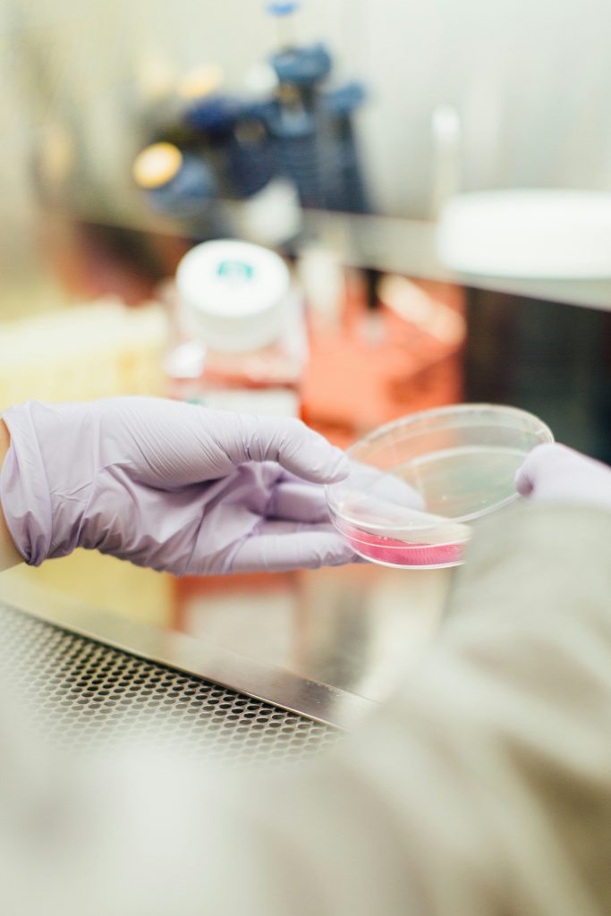 Scientist handling peptide research compounds with laboratory equipment during controlled scientific analysis.